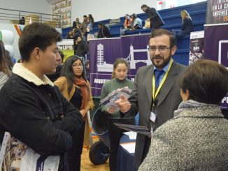 Jefes de carrera explicando a padres e hijos las diferentes carreras de la UPB durante la feria