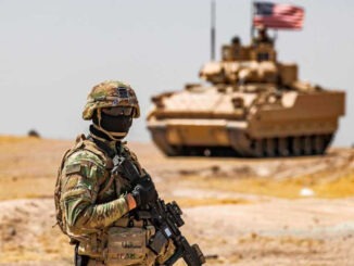 A US soldier stands near a Bradley Fighting Vehicle (BFV) during
